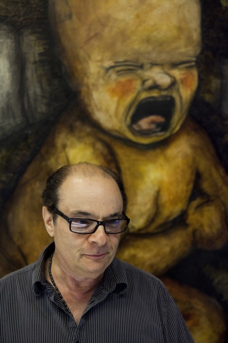 Man in front of painting of crying baby